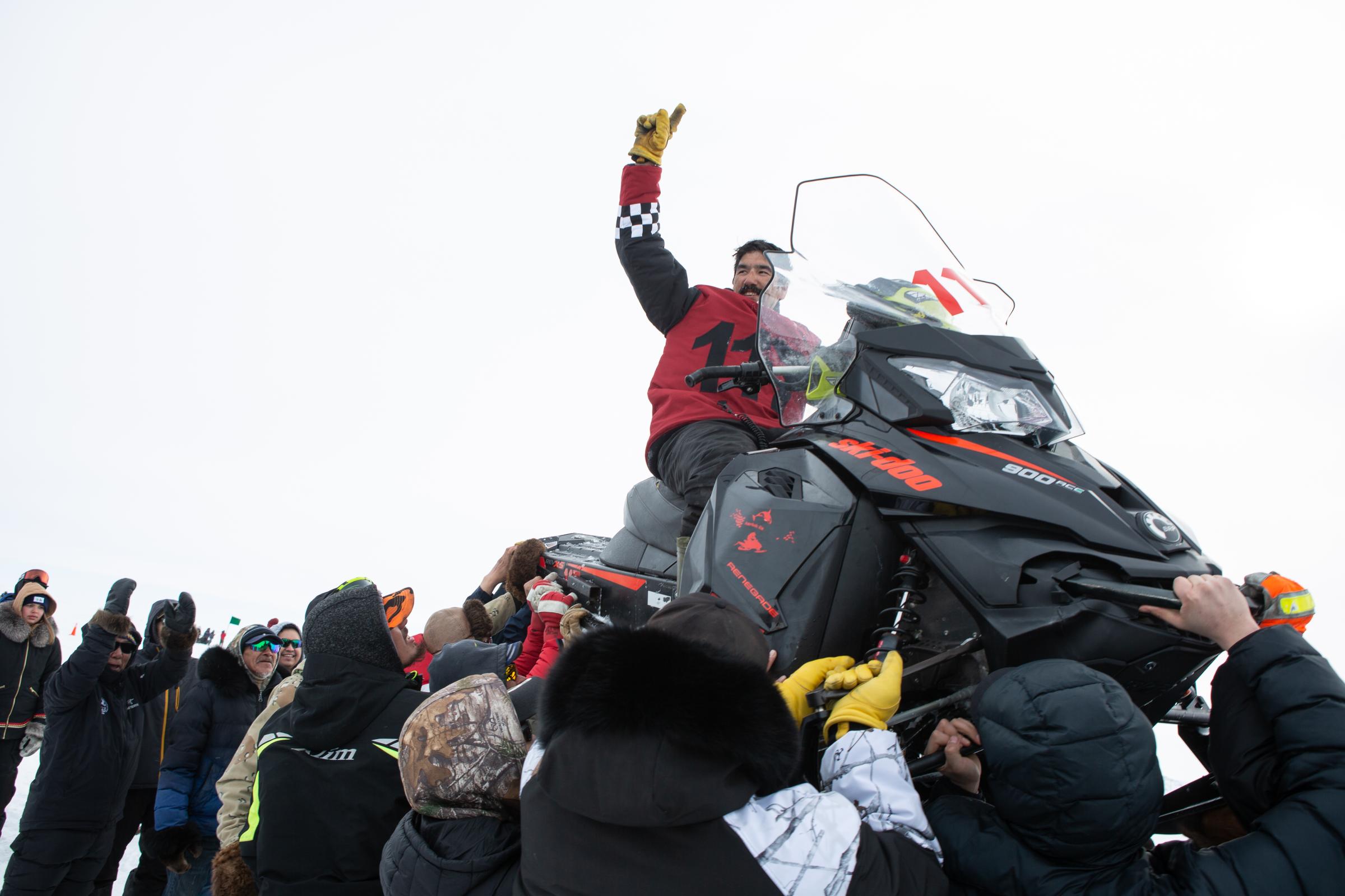 An Arctic blast - Billy Kilabuk celebrates winning the snowmobile race from...