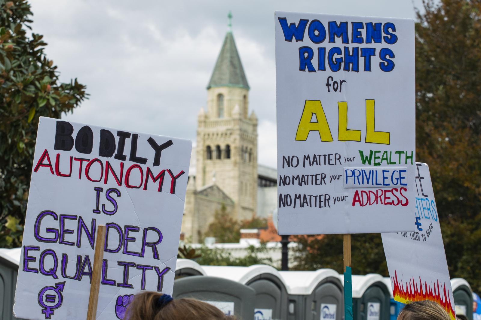 Demonstrators hold signs during the Women