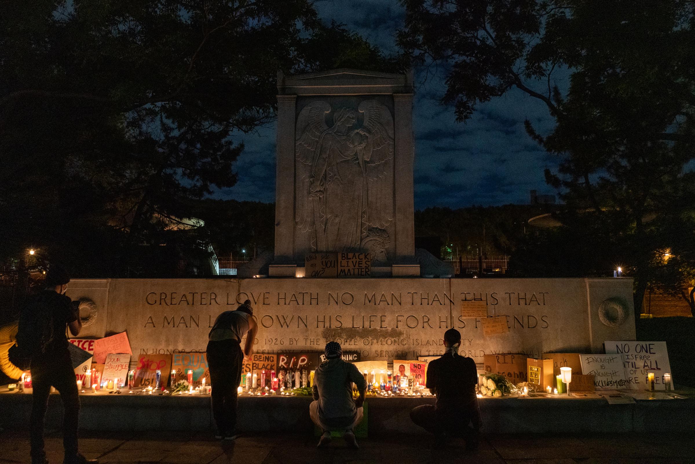 Black Lives Matter Movement 2020 - Vigil attendees place candles, flowers, and signage in...