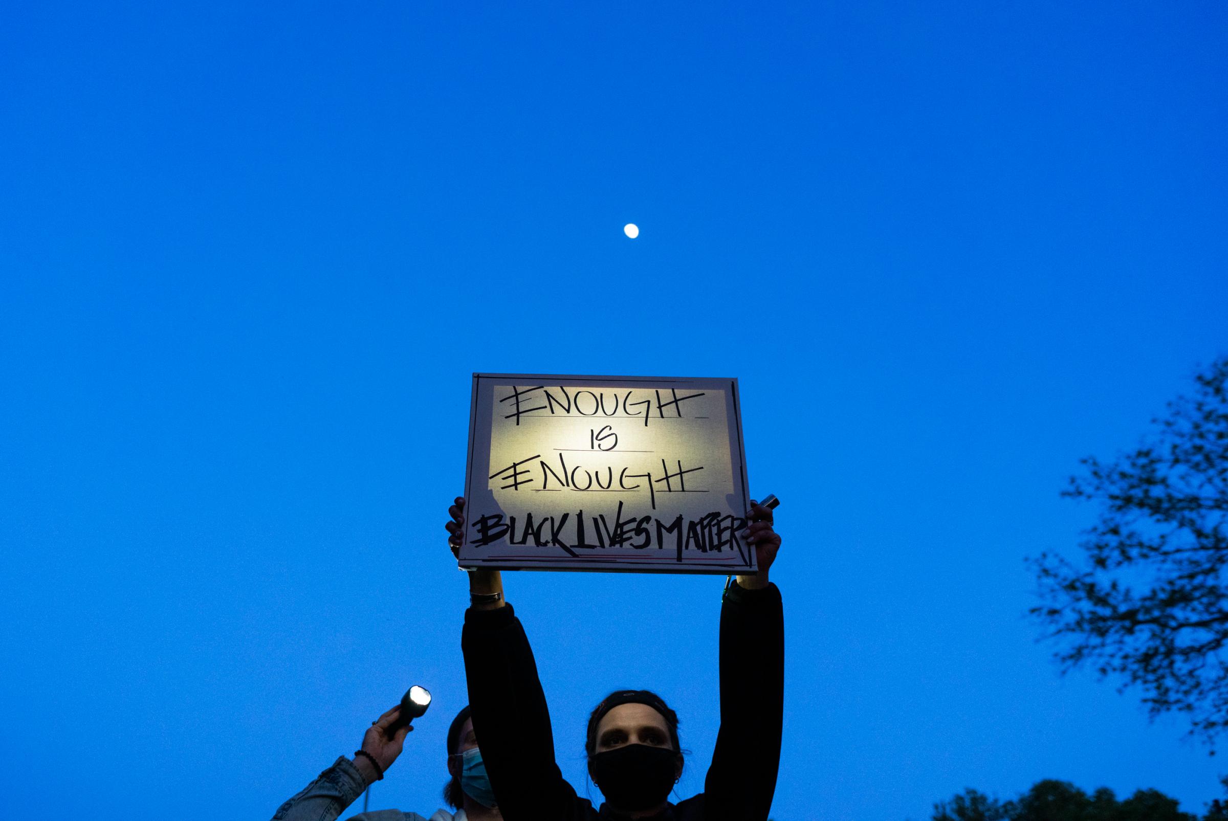 Black Lives Matter Movement 2020 - A vigil attendee holds a Black Lives Matter sign during a...