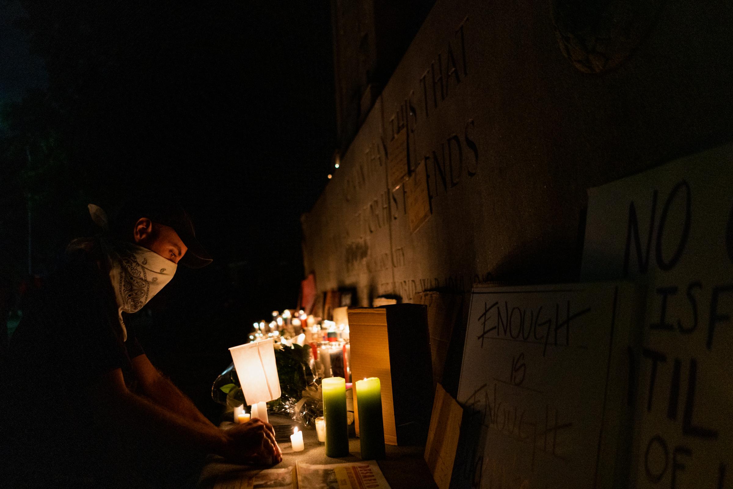 Black Lives Matter Movement 2020 - A demonstrator kneels at a memorial that commemorates the...