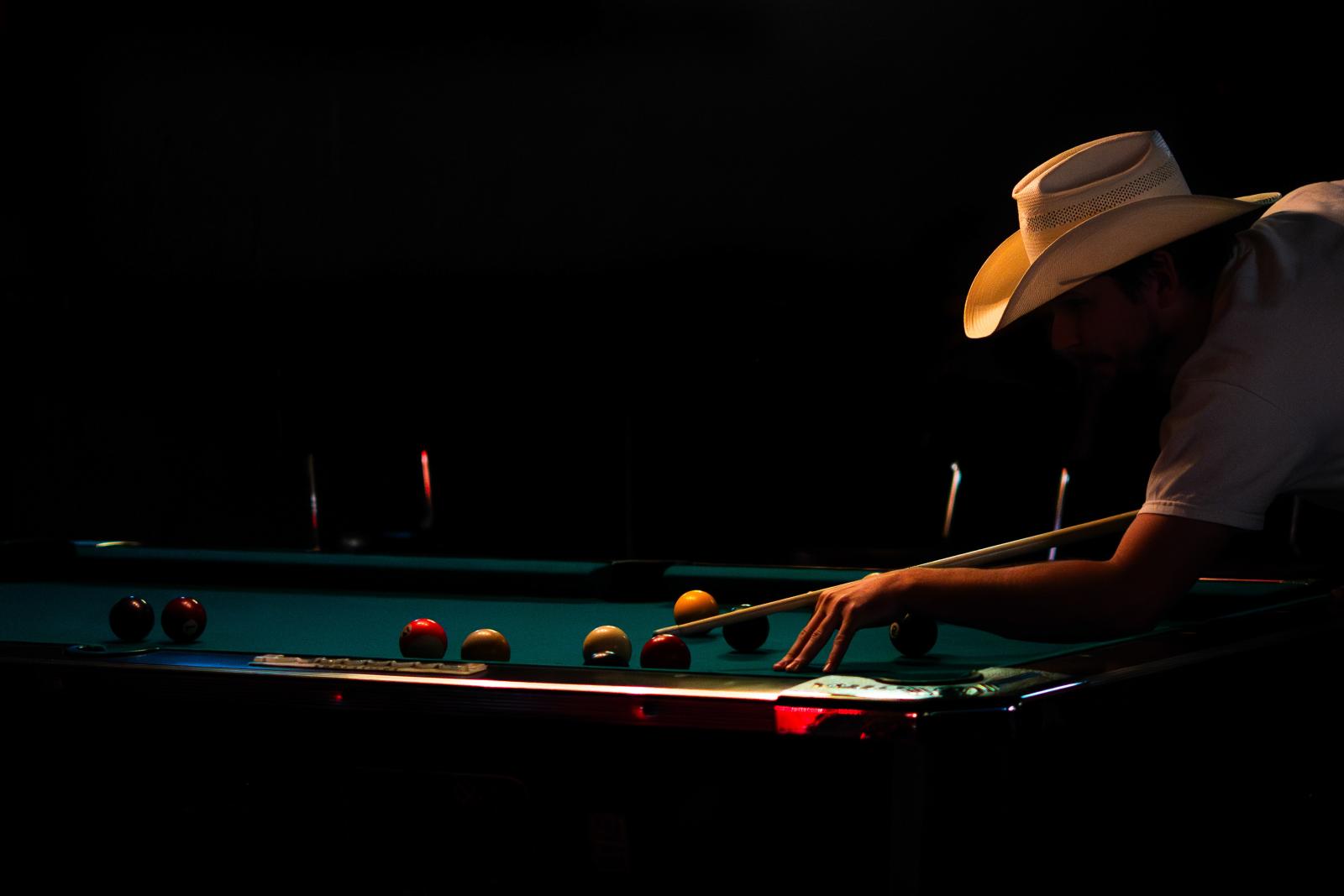 A cowboy plays a game of pool a...al Club in downtown Austin, TX.