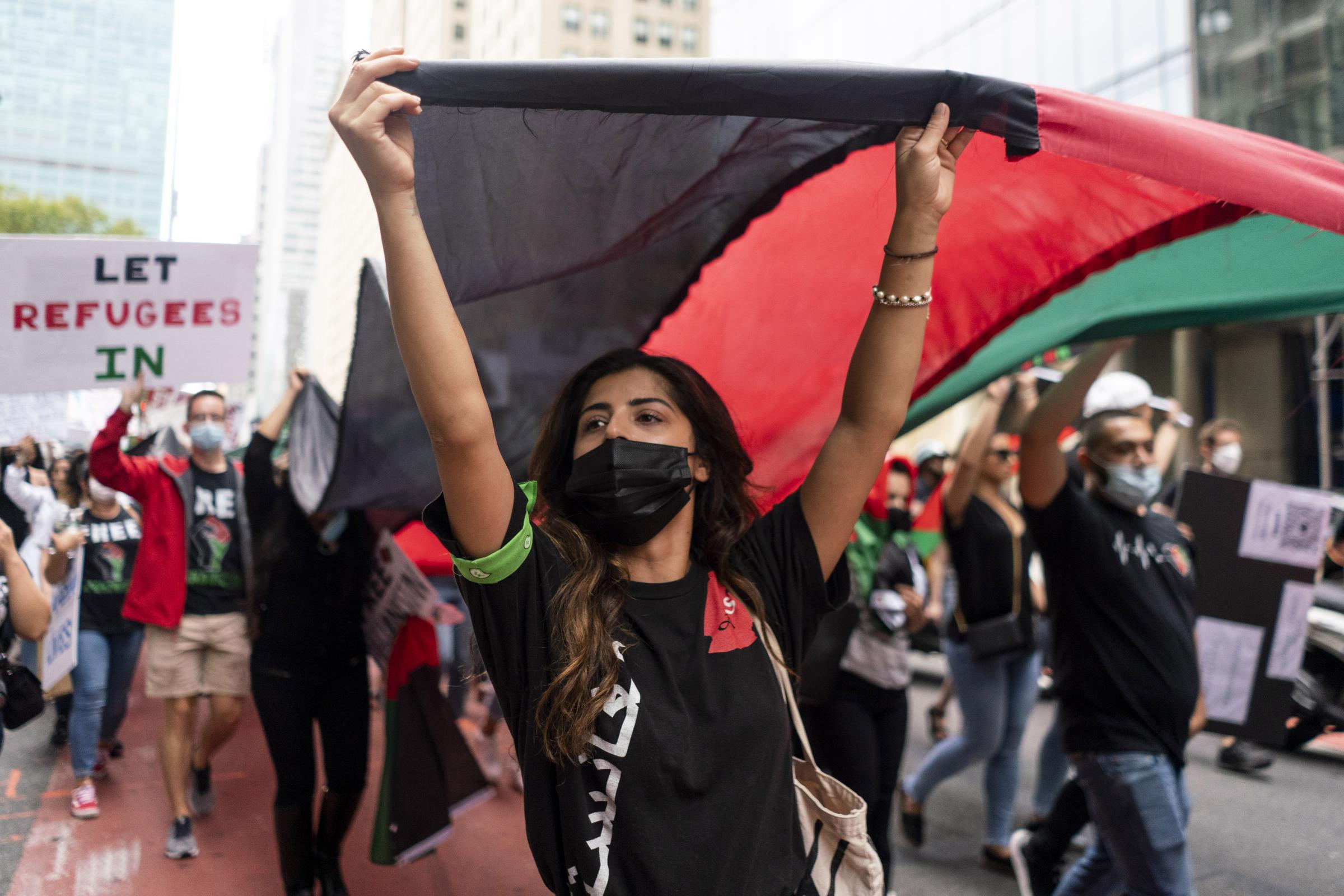 Singles - Demonstrators march with an Afghan flag during a...