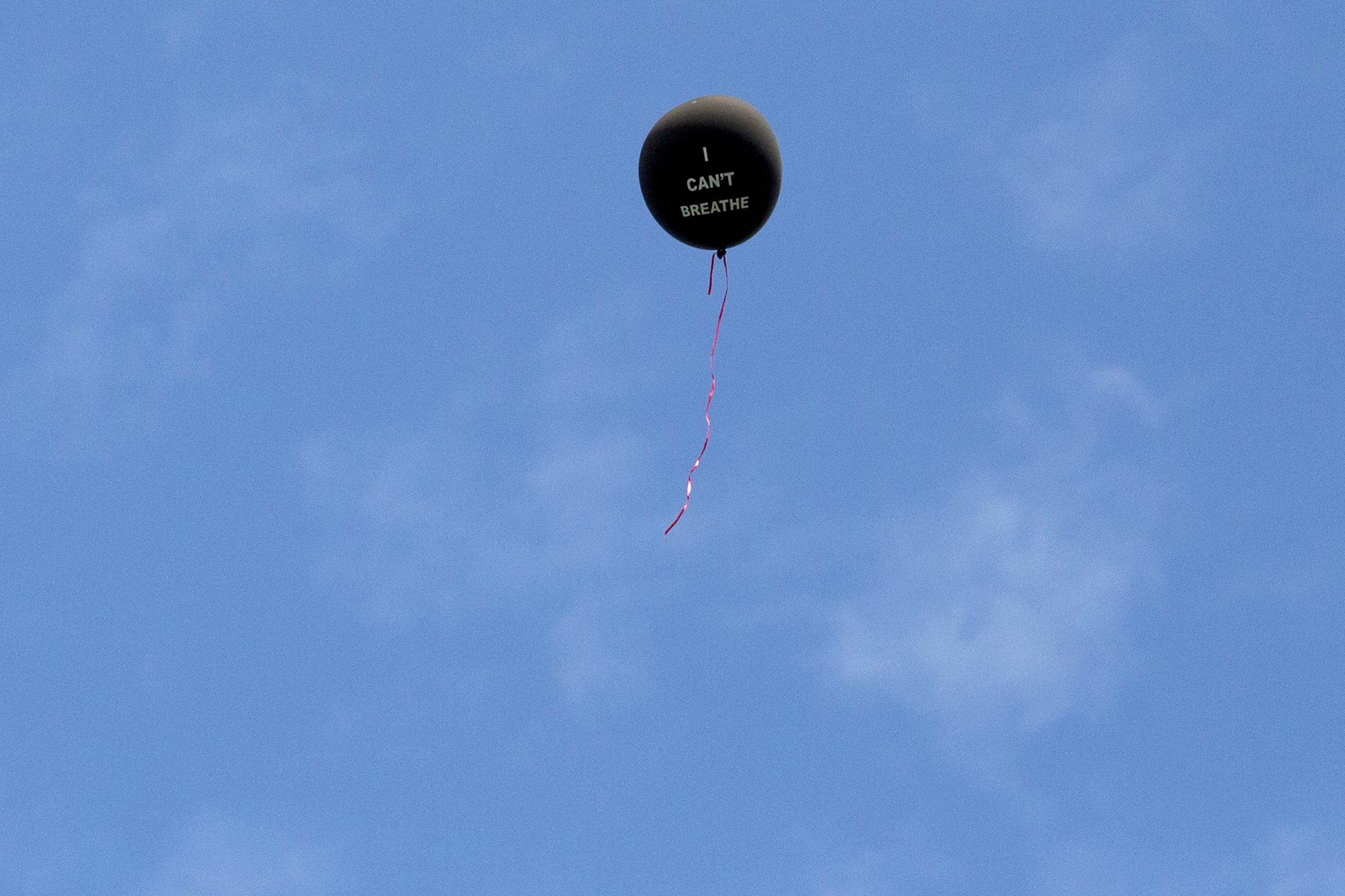 Singles - An “I Can’t Breathe” balloon floats in...