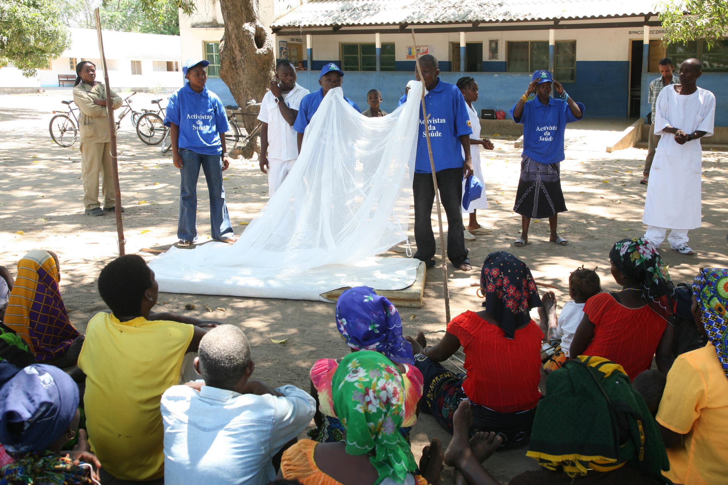 Malaria - Health workers giving instructions on how to use mosquito...
