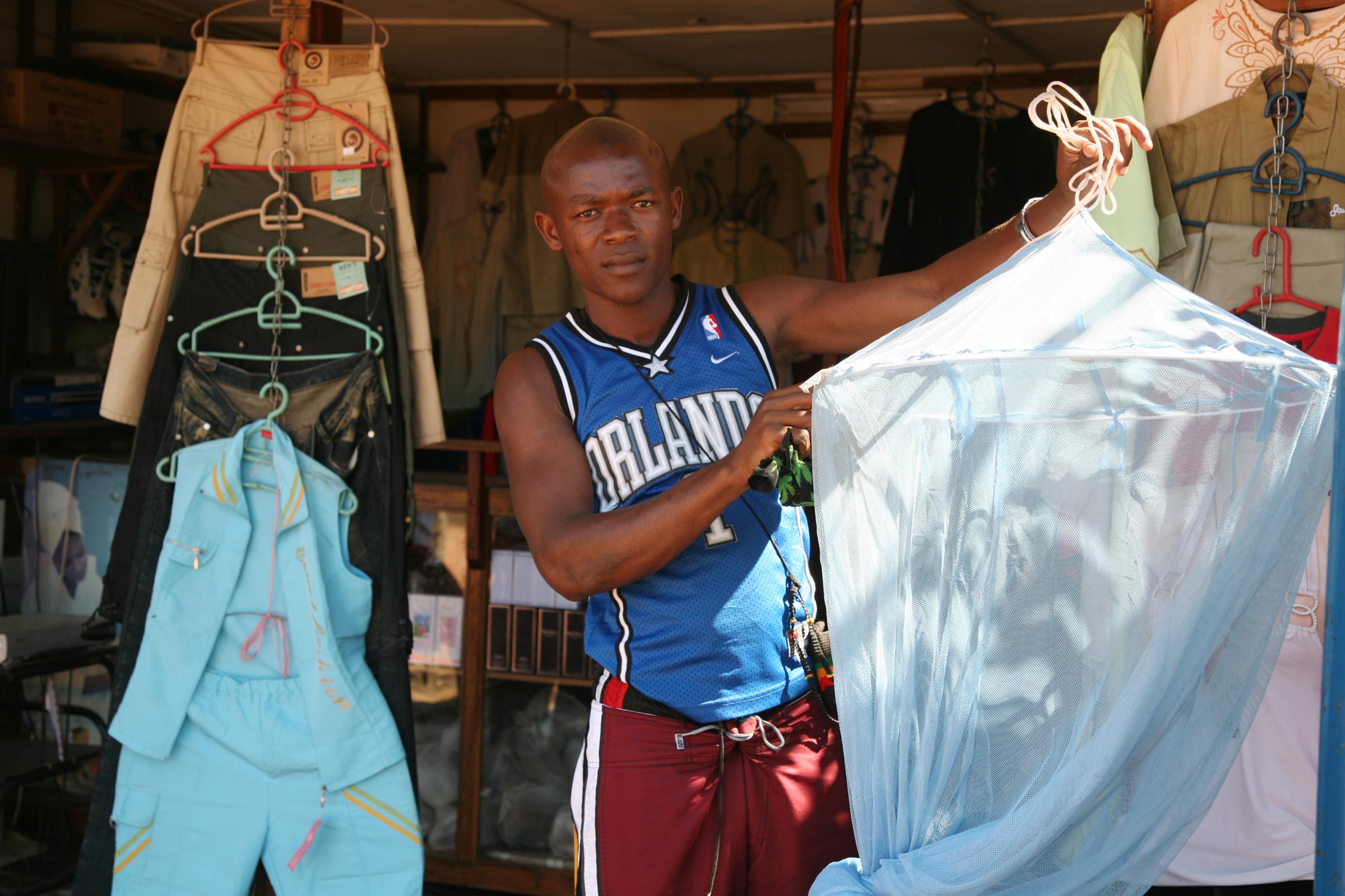 Malaria - Ahmed Valeriano, treated mosquito net seller at Mbanguia...