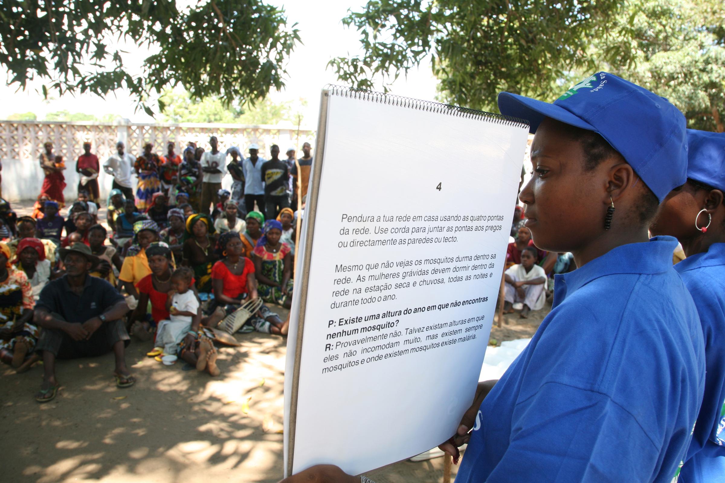 Malaria - Health volunteers explain to rural women how to use...
