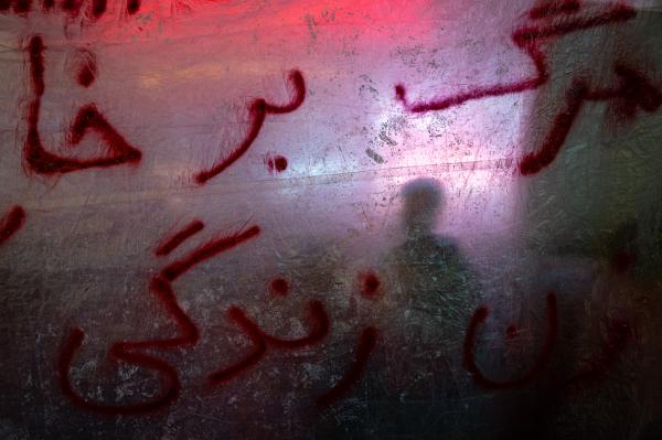 SINGLES - An Iranian protester can be seen backlit from a protest...