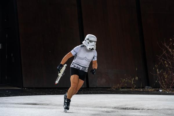 SINGLES - An ice skater wearing a Storm Trooper helmet and holding...