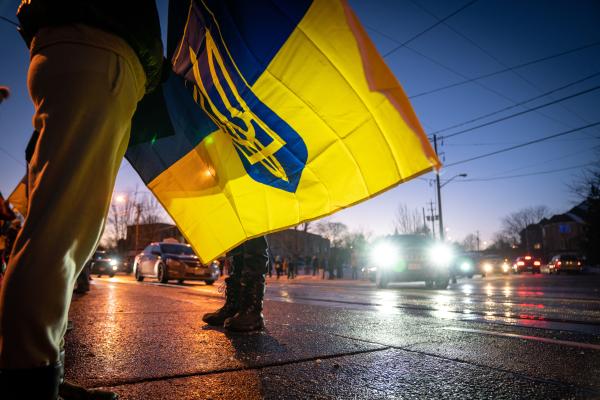 Image from [Ongoing] Ukrainian Toronto Protests - A protestor holding a Ukrainian flag with the Ukrainian...