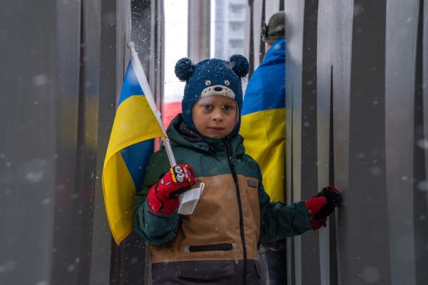 Image from [Ongoing] Ukrainian Toronto Protests - A young boy holding a Ukrainian flag in between a...