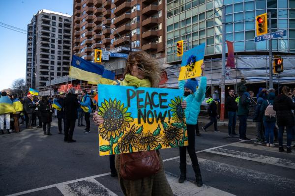 Image from [Ongoing] Ukrainian Toronto Protests - A woman holds up a “Peace Now” sign during a...