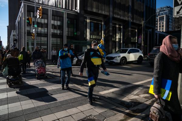 Image from [Ongoing] Ukrainian Toronto Protests - A man wearing Ukrainian flags on his body crosses the...