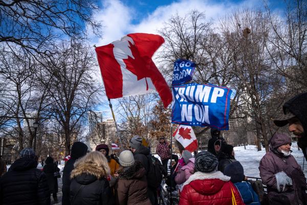 Protestors waving Canadian and pro-Trump flags surrounding a monument. Trucker convoy protesters gather in Queen’s Park, Toronto for the second consecutive weekend in solidarity with anti-mandate demonstrations on February 12, 2021. It comes after the province declared a state of emergency in relation to the ongoing blockades, with Toronto police setting up road closures across the city.
