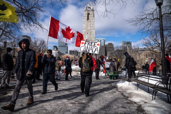 Protestors waving Canadian flags and a “Free Canada” sign in front of a pillar. Trucker convoy protesters gather in Queen’s Park, Toronto for the second consecutive weekend in solidarity with anti-mandate demonstrations on February 12, 2021. It comes after the province declared a state of emergency in relation to the ongoing blockades, with Toronto police setting up road closures across the city.
