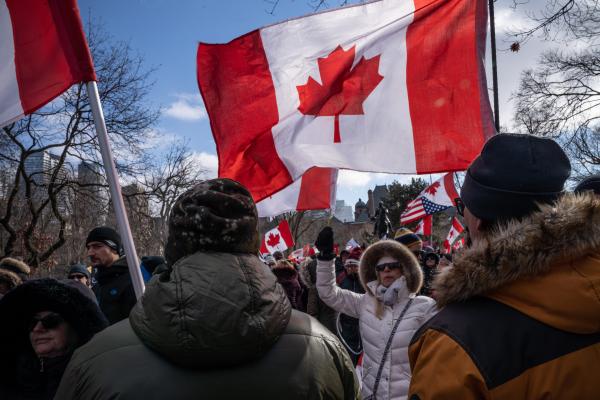 A woman protestor waving a Canadian flag during a rally. Trucker convoy protesters gather in Queen’s Park, Toronto for the second consecutive weekend in solidarity with anti-mandate demonstrations on February 12, 2021. It comes after the province declared a state of emergency in relation to the ongoing blockades, with Toronto police setting up road closures across the city.