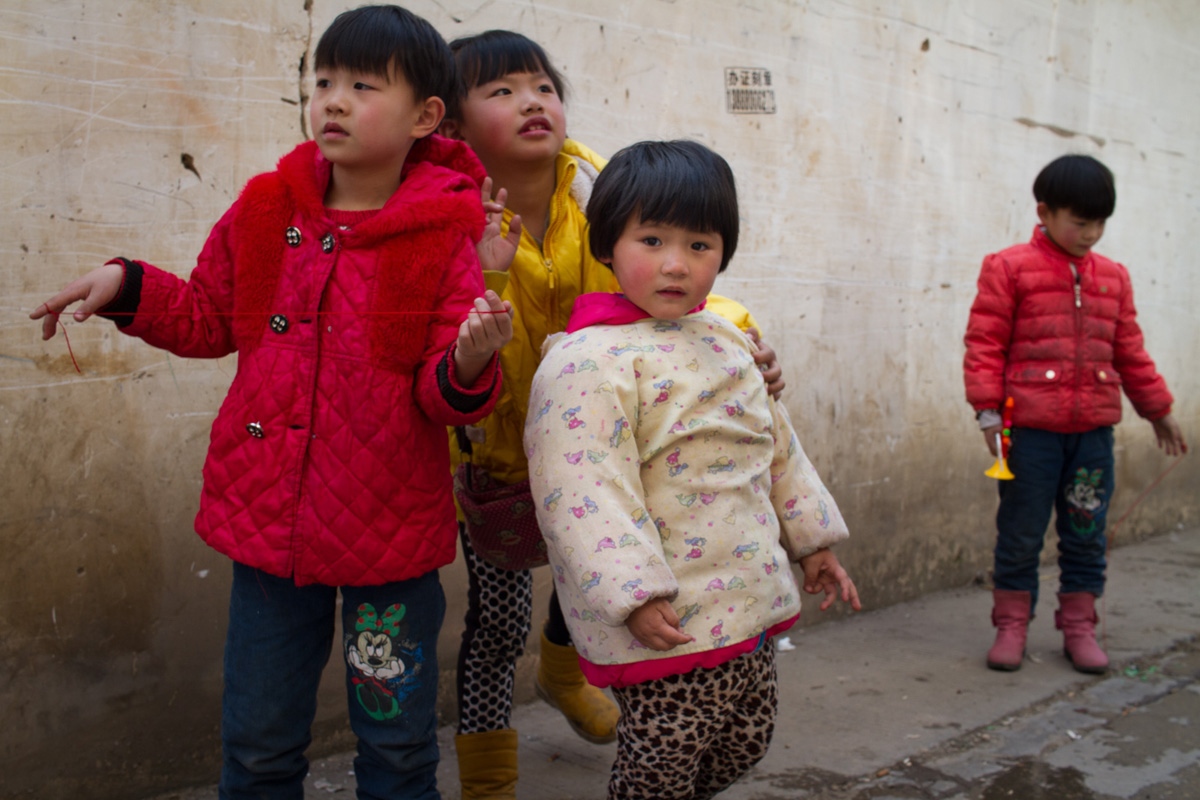 Singles -  Children dress up and play in an alley way before the...