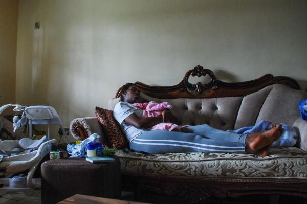 Image from Fashioning a Business - After a long day, Motapwa dozes off while holding baby...