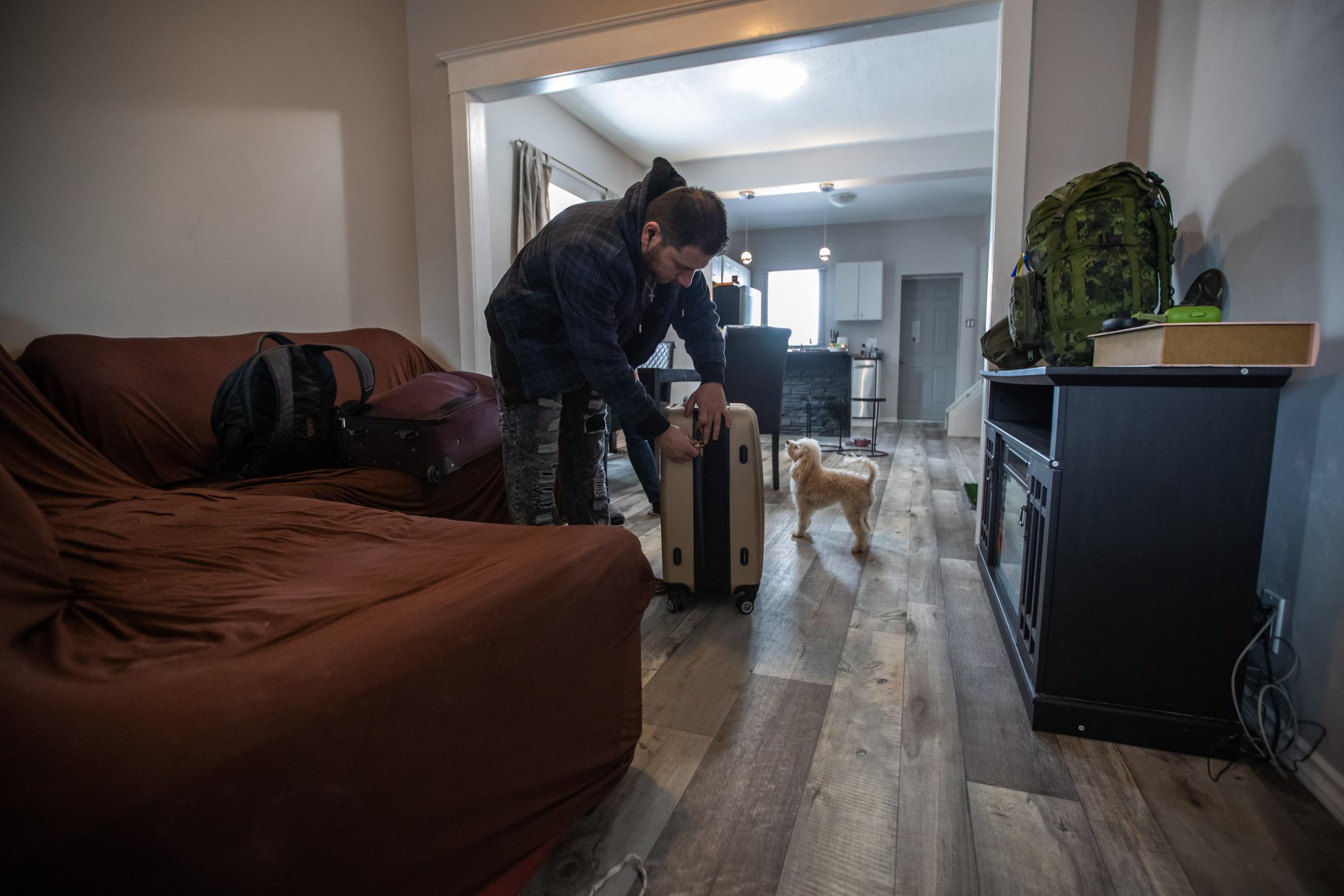 Vartan Davtian closes a suitcase as he prepares to leave his home in Brandon, Manitoba, and travel to Europe to support the Ukrainian resistance....