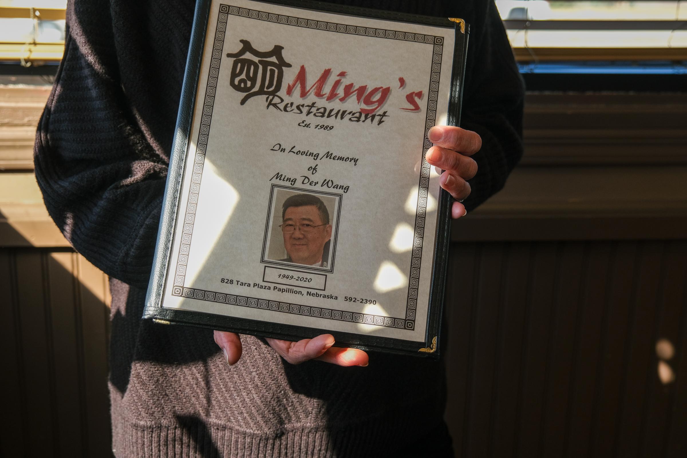 PAPILLION, NE - MARCH 19, 2022: Lu Wang holds a menu with a dedication to Ming Wang inside of Ming&#39;s Restaurant in Papillion, Nebraska on March 19, 2022. (Photo by Arin Yoon for The Washington Post) Papillion United States