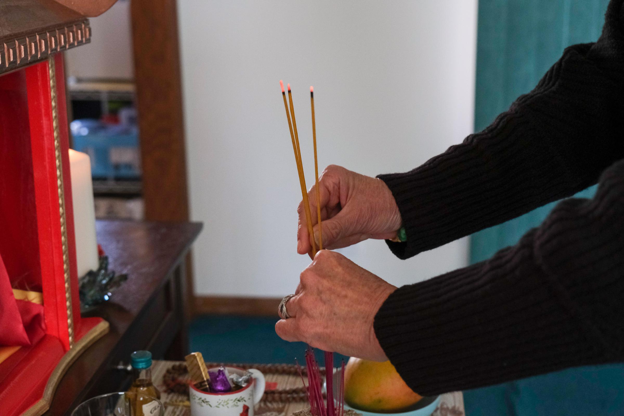 PAPILLION, NE - MARCH 19, 2022: Lu Wang lights incense every morning in honor of Ming Wang in her home in Papillion, Nebraska on March 19, 2022. (Photo by Arin Yoon for The Washington Post) Papillion United States