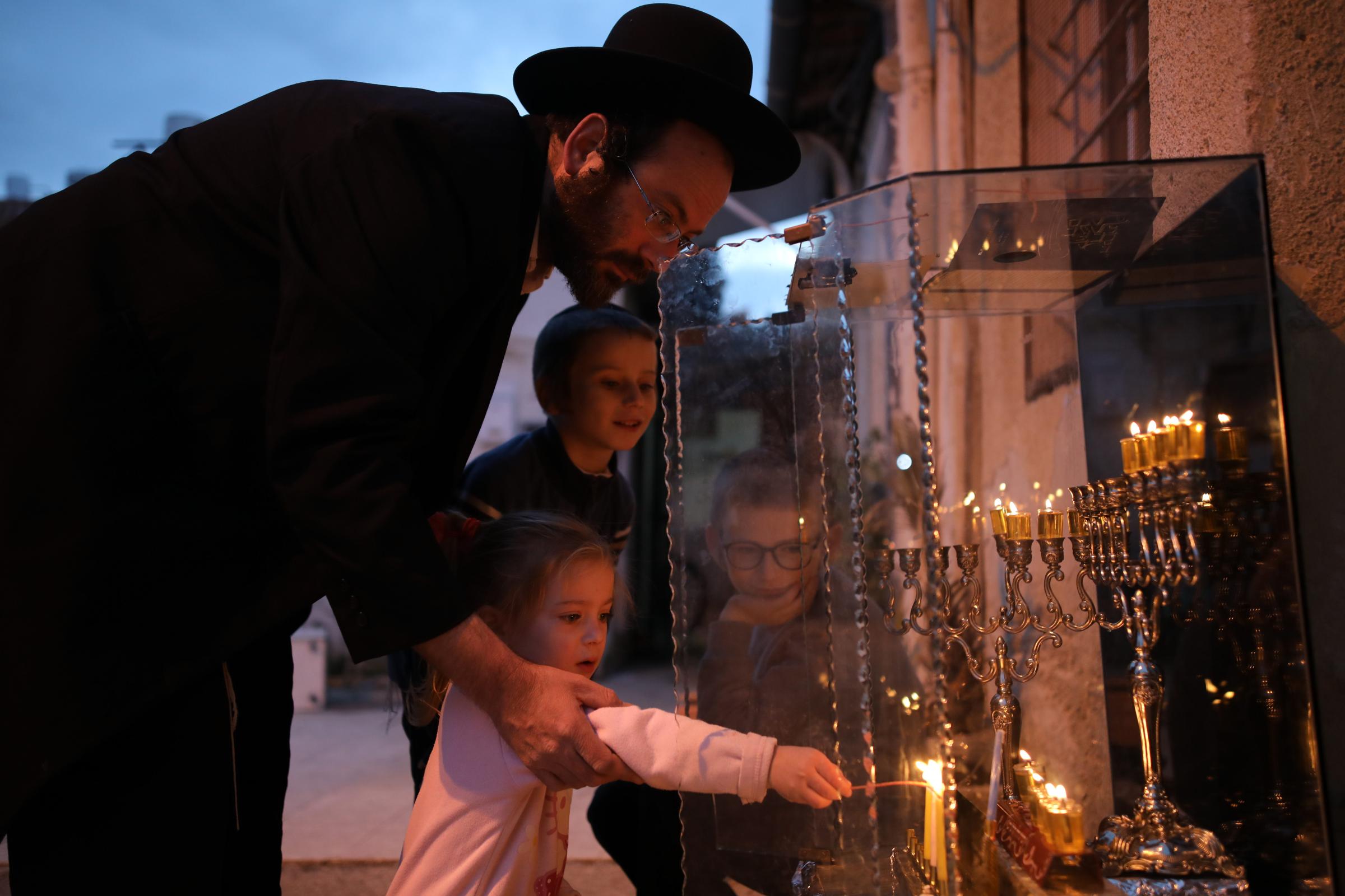 Ultra-Orthodox Community - An ultra-orthodox Jewish family lights candles at their...
