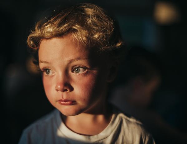Gannon Ryan, 5, stares out of the window as the sun sets on Nantucket Island, Mass. in mid July. This image was enhanced with Adobe Lightroom. 