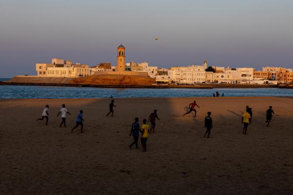 In Oman, a Dagger Symbolizes National Pride - SUR, OMAN-&shy;‐ NOVEMBER 21, 2022: Youth play football on the beach in Sur. CREDIT: Katarina...