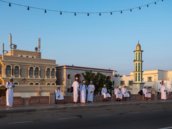 In Oman, a Dagger Symbolizes National Pride - SUR, OMAN-&shy;‐ NOVEMBER 22, 2022: Student wait for the morning school bus. The boys wear...