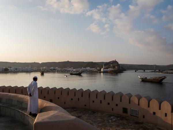 In Oman, a Dagger Symbolizes National Pride - SUR, OMAN-&shy;‐ NOVEMBER 22, 2022: A Sur resident watches the dhows come back to shore....