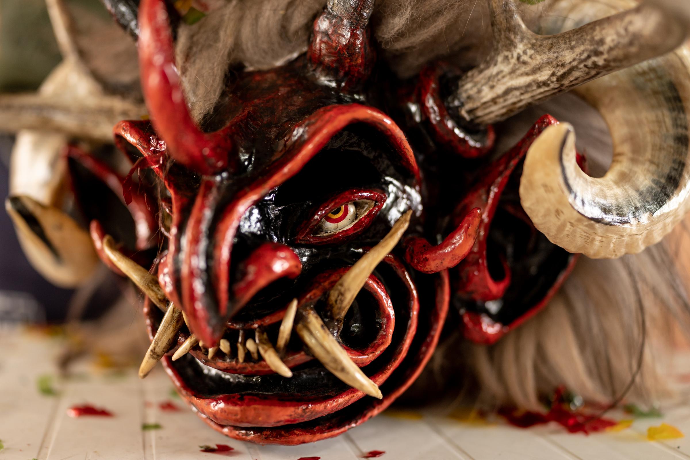 Los Diablos de Píllaro - A devil mask rest on a table inside the workshop of the...