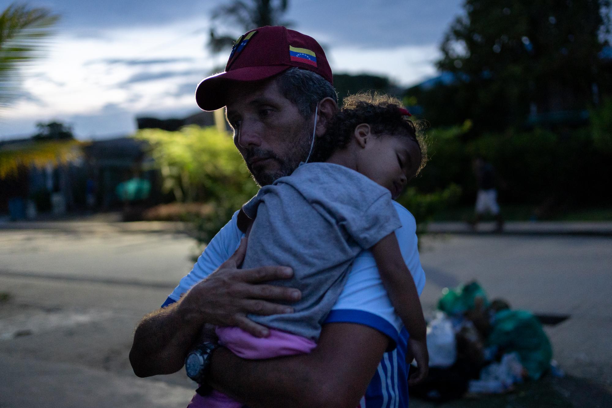 Inside The Derian Gap - A Venezuelan migrant holds his young daughter near where...