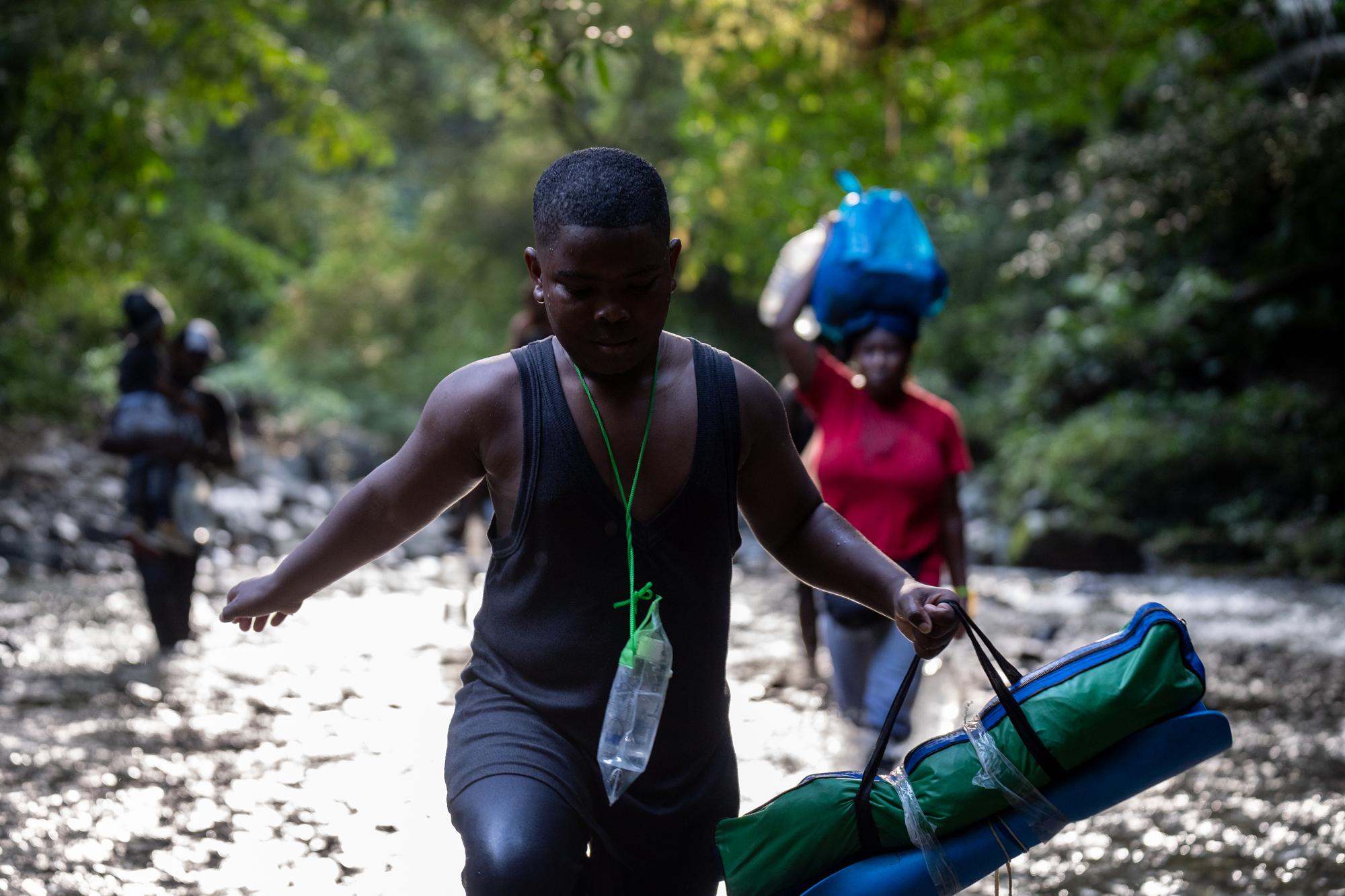 Inside The Derian Gap - A young boy walks through a shallow river inside the...