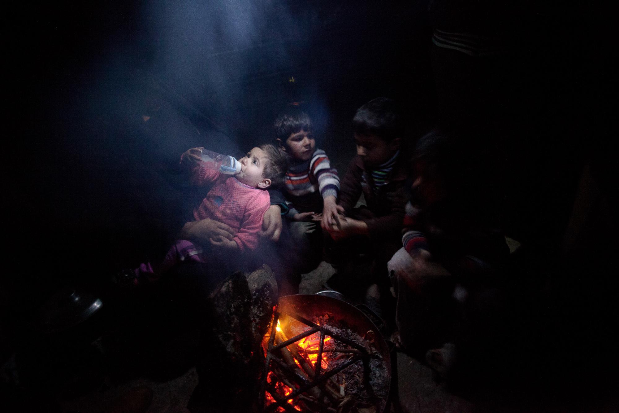 Life Under Siege - GAZA STRIP,Palestinian children gathering around fire...