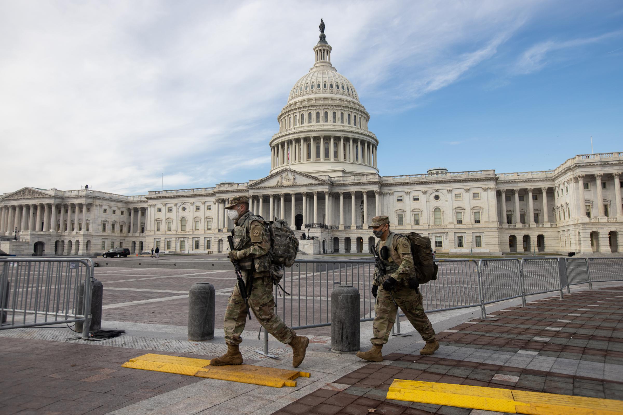 Members of the National Guard walk past the Dome of the Capitol Building on Capitol Hill in...