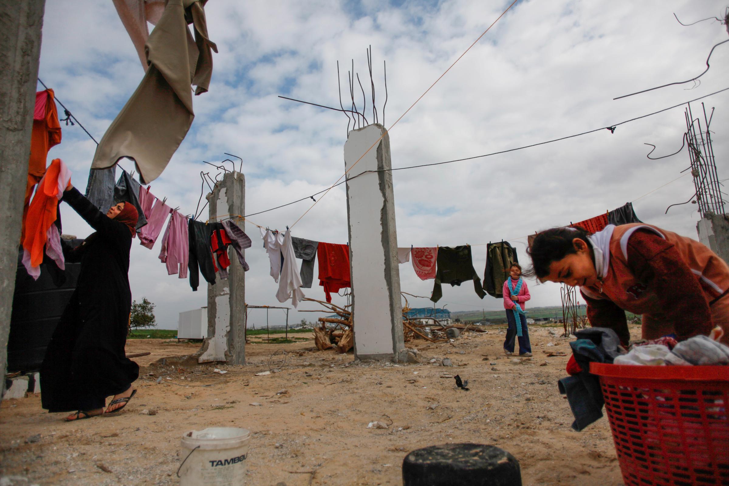 GAZA STRIP, PALESTINE.Northern Gaza Strip, Palestine.Palestinian girls hanging laundry on the remaining pillars of their destroyed house in the...