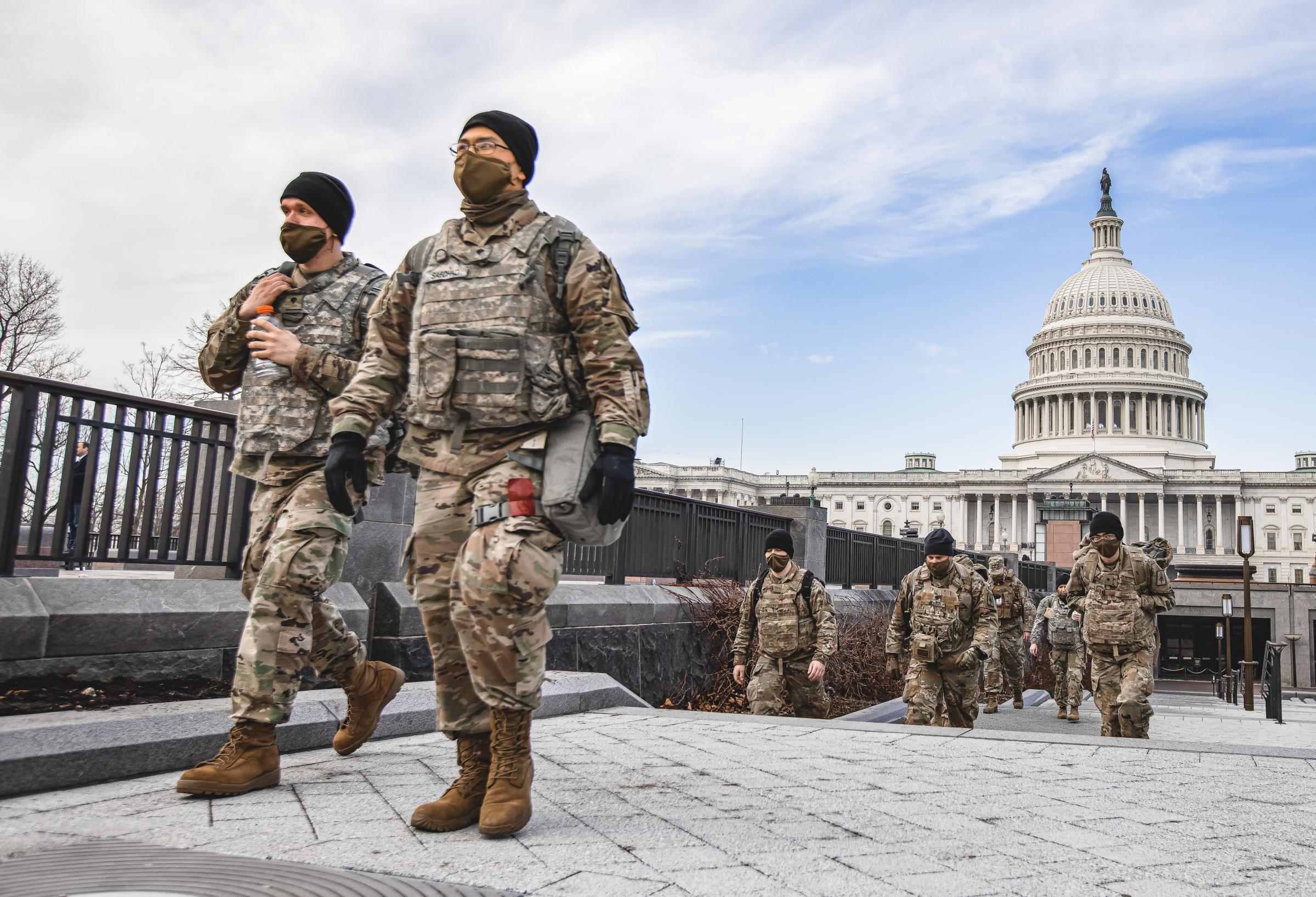 Members of the National Guard walk past the Dome of the Capitol Building on Capitol Hill in...