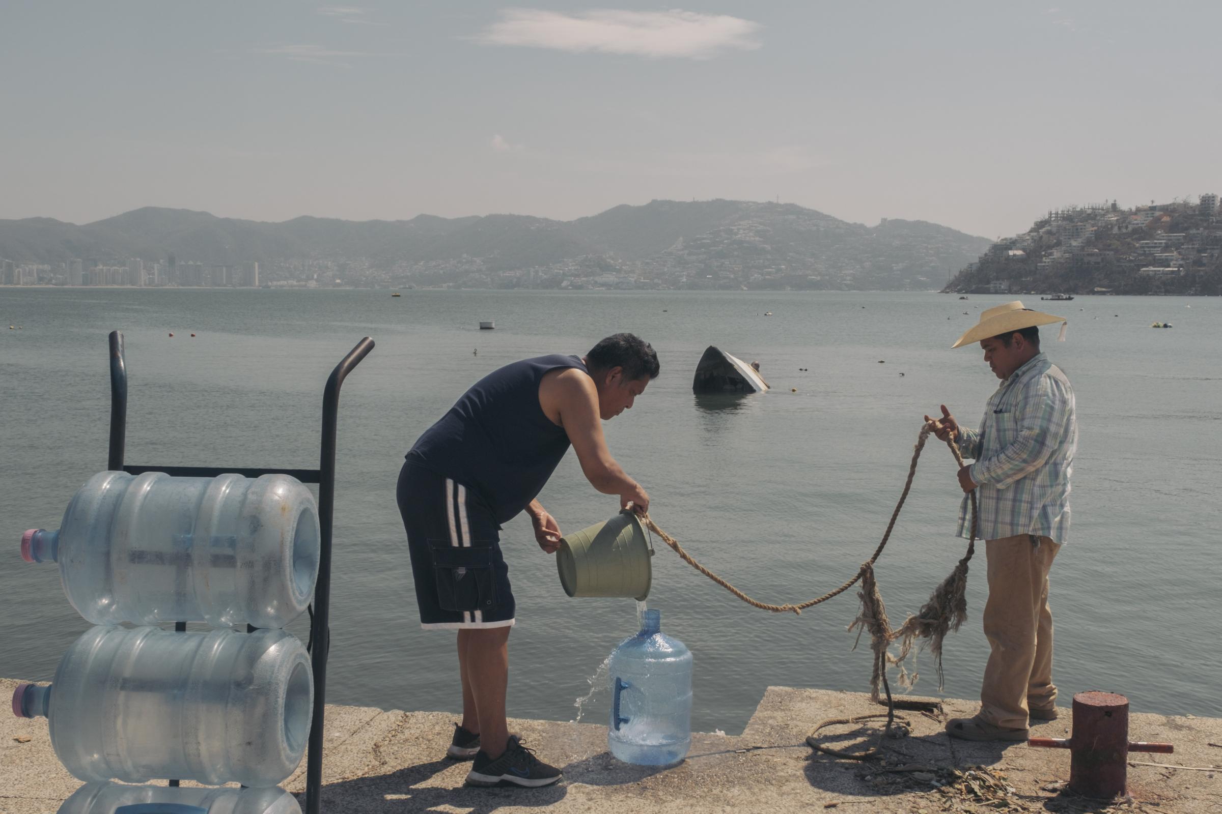 Acapulco - Hurricane Otis - With no running water available, residents living by the...