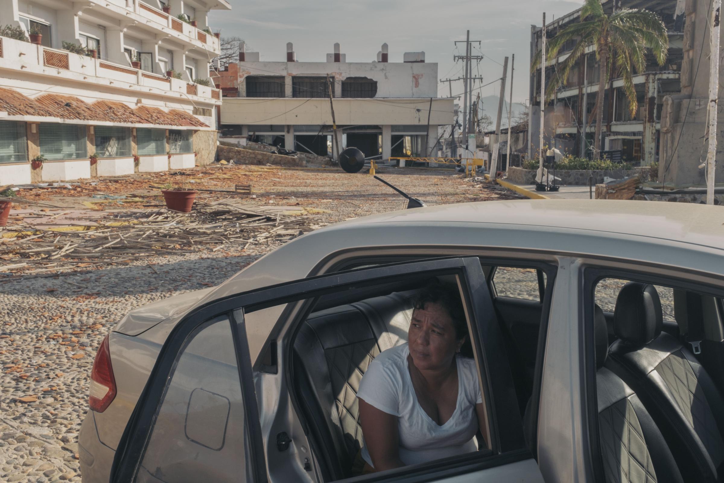Acapulco - Hurricane Otis - Iris Apac sits in her car parked in front of the Hotel El...