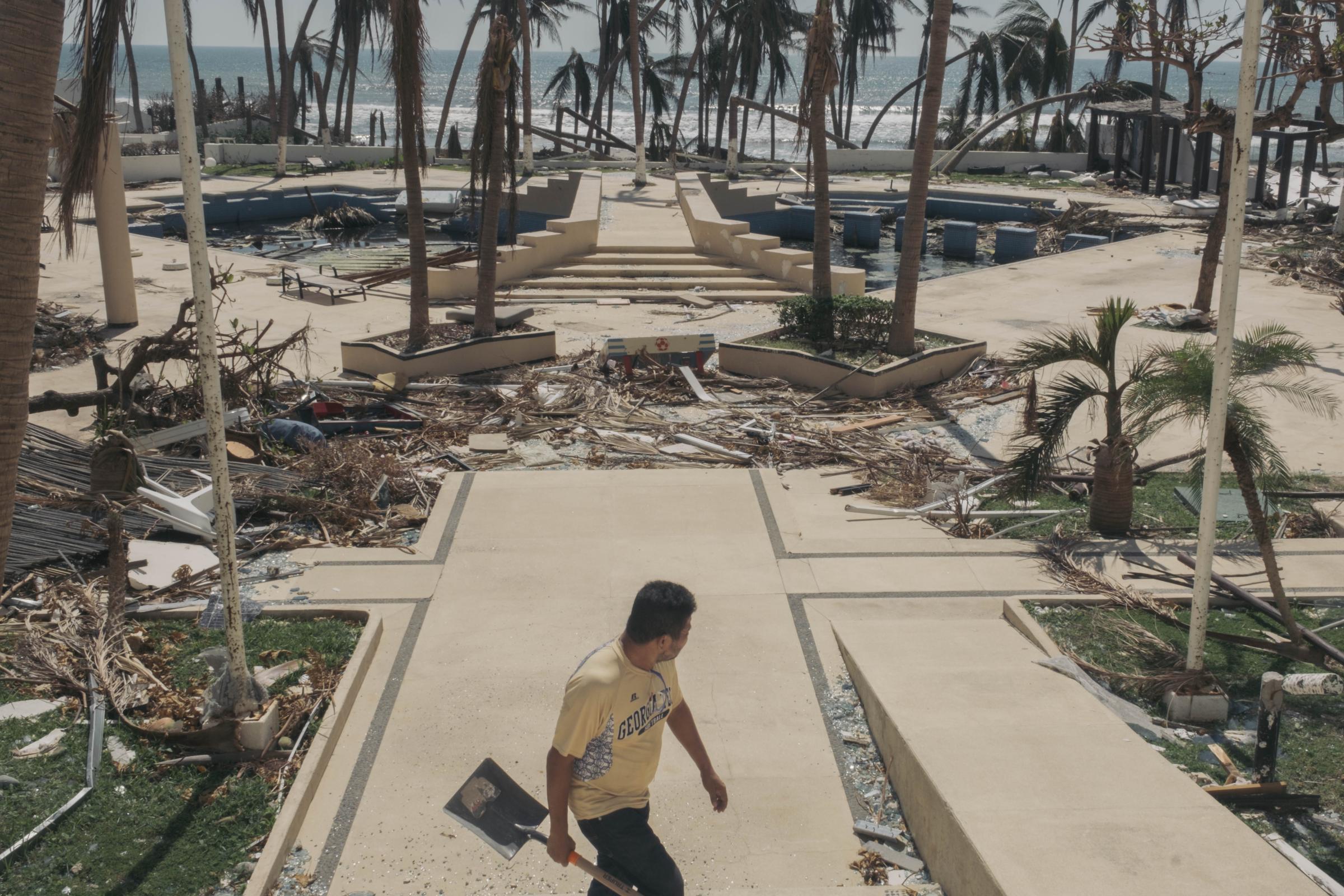 Acapulco - Hurricane Otis - Un employé débarrasse les débris dans la cour d'une...