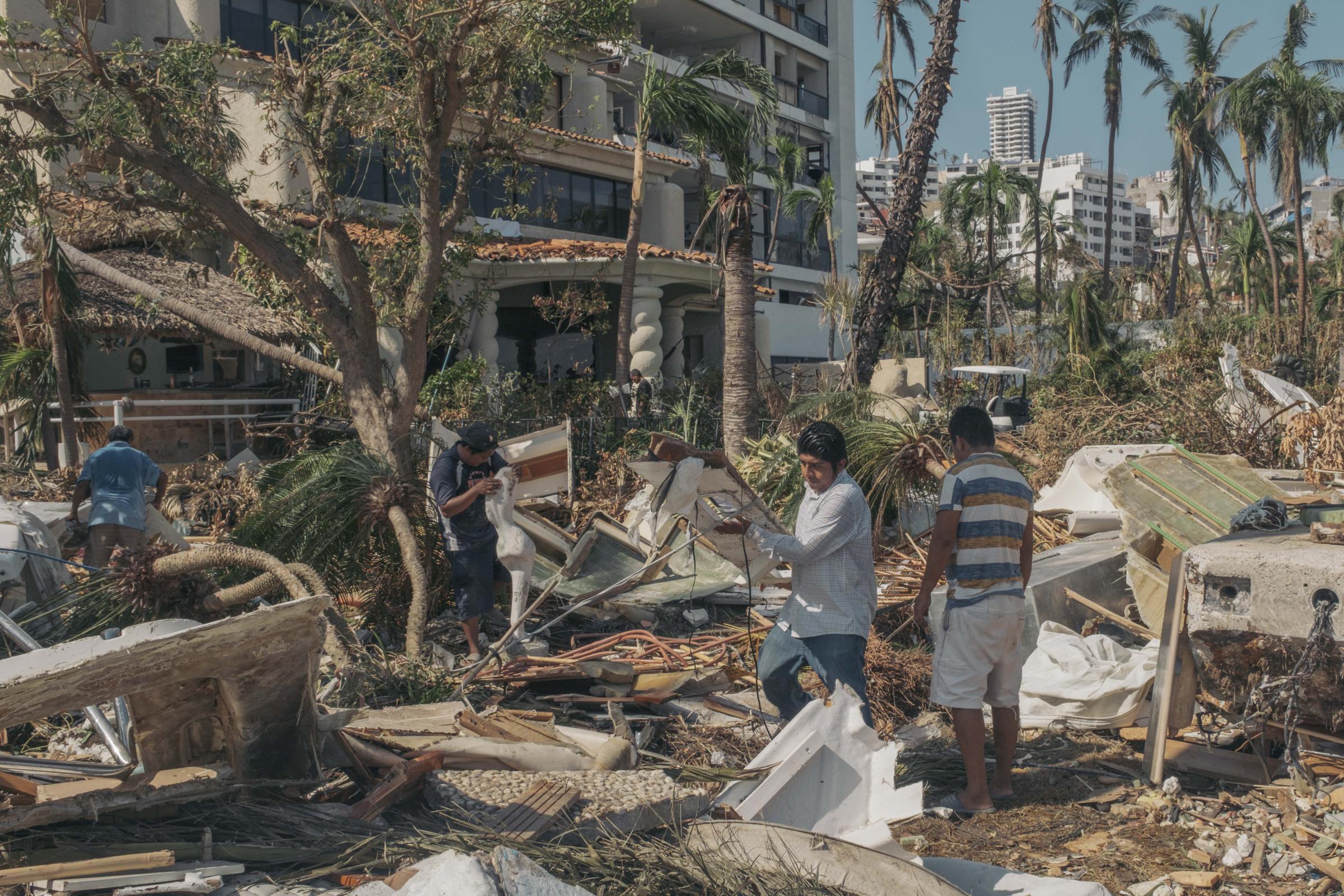 Acapulco - Hurricane Otis - Des employés débarrassent les débris dans le jardin d'une...