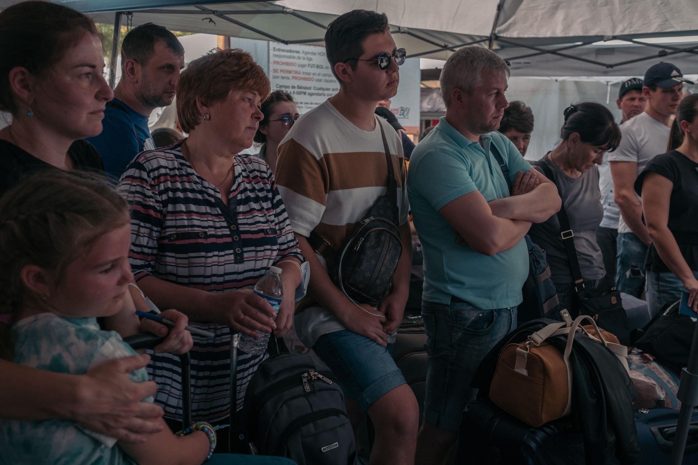 Le Monde - Ukrainian Refugees in Tijuana - Ukrainian refugees wait to board the bus that will take...