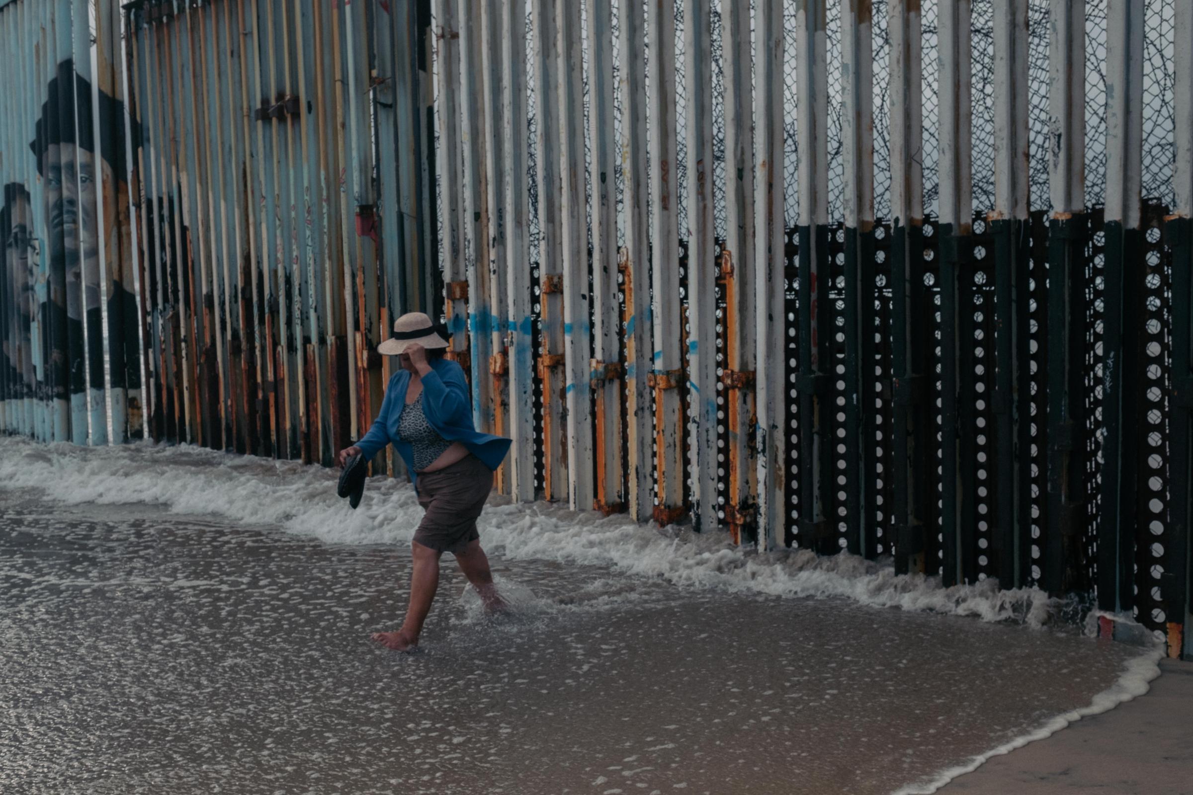 Le Monde - Ukrainian Refugees in Tijuana - A tourist walks near the border wall that separates...