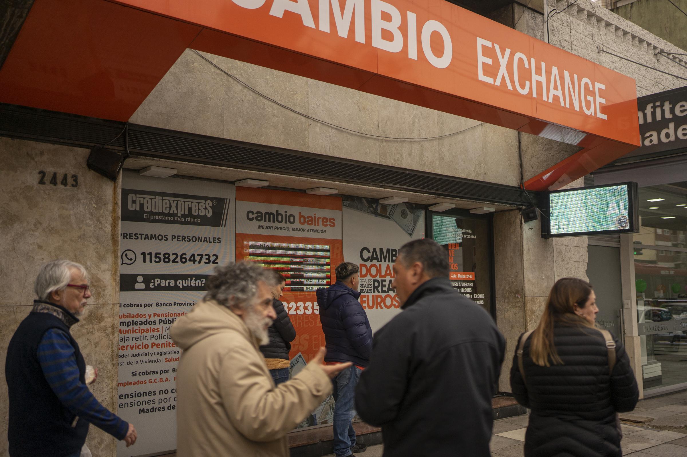 Argentina Inflation  - A line of people waits to enter a currency exchange to...