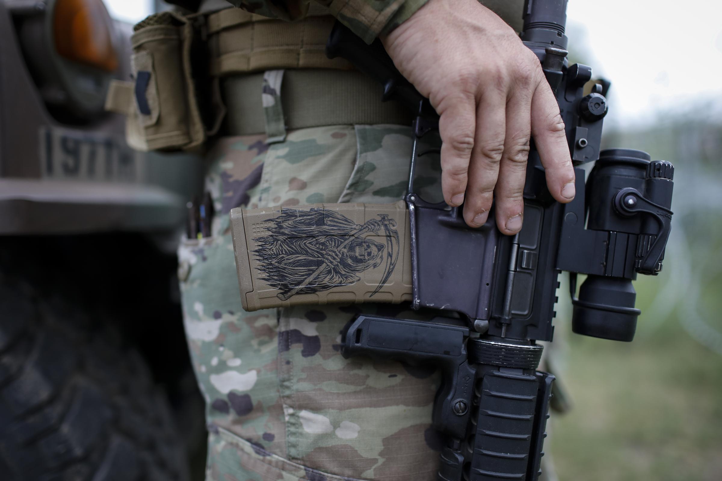 slideshow - A detail on the assault rifle of a Texas Army National Guard member standing guard in the north...