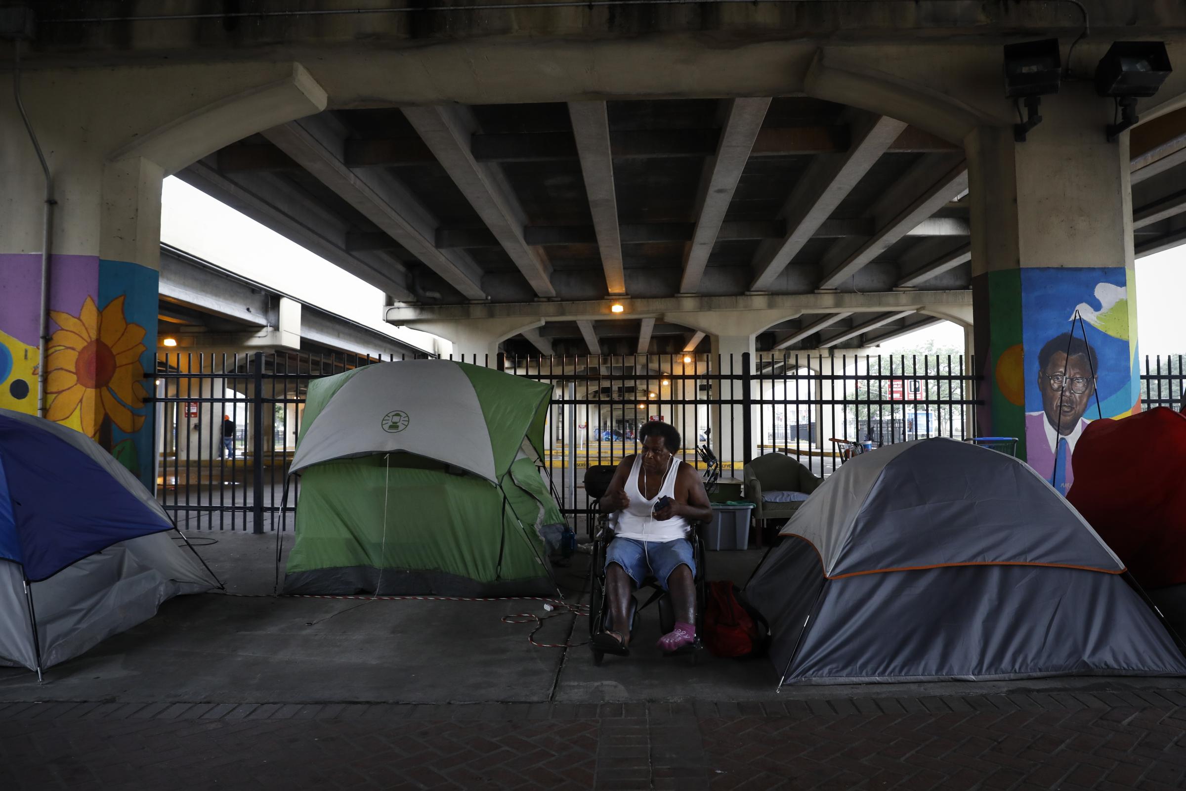 slideshow - Greg King, 62, a homeless man, sits outside his tent under an expressway ahead of Hurricane Ida,...