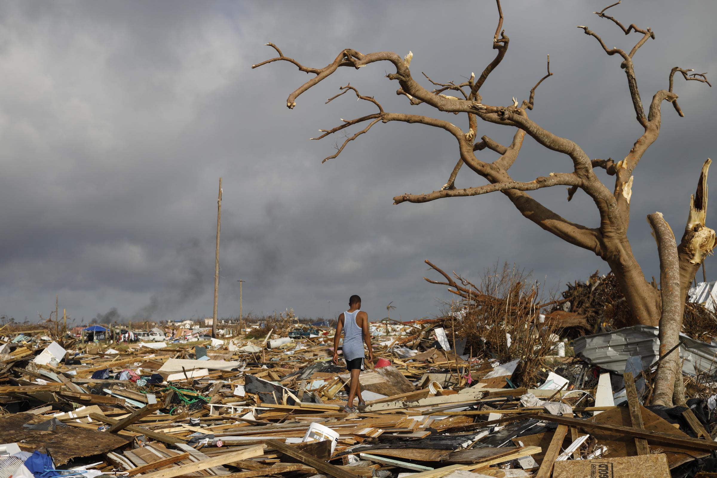 slideshow - A man walks among debris at The Mud neighborhood, devastated after Hurricane Dorian hit the Abaco...