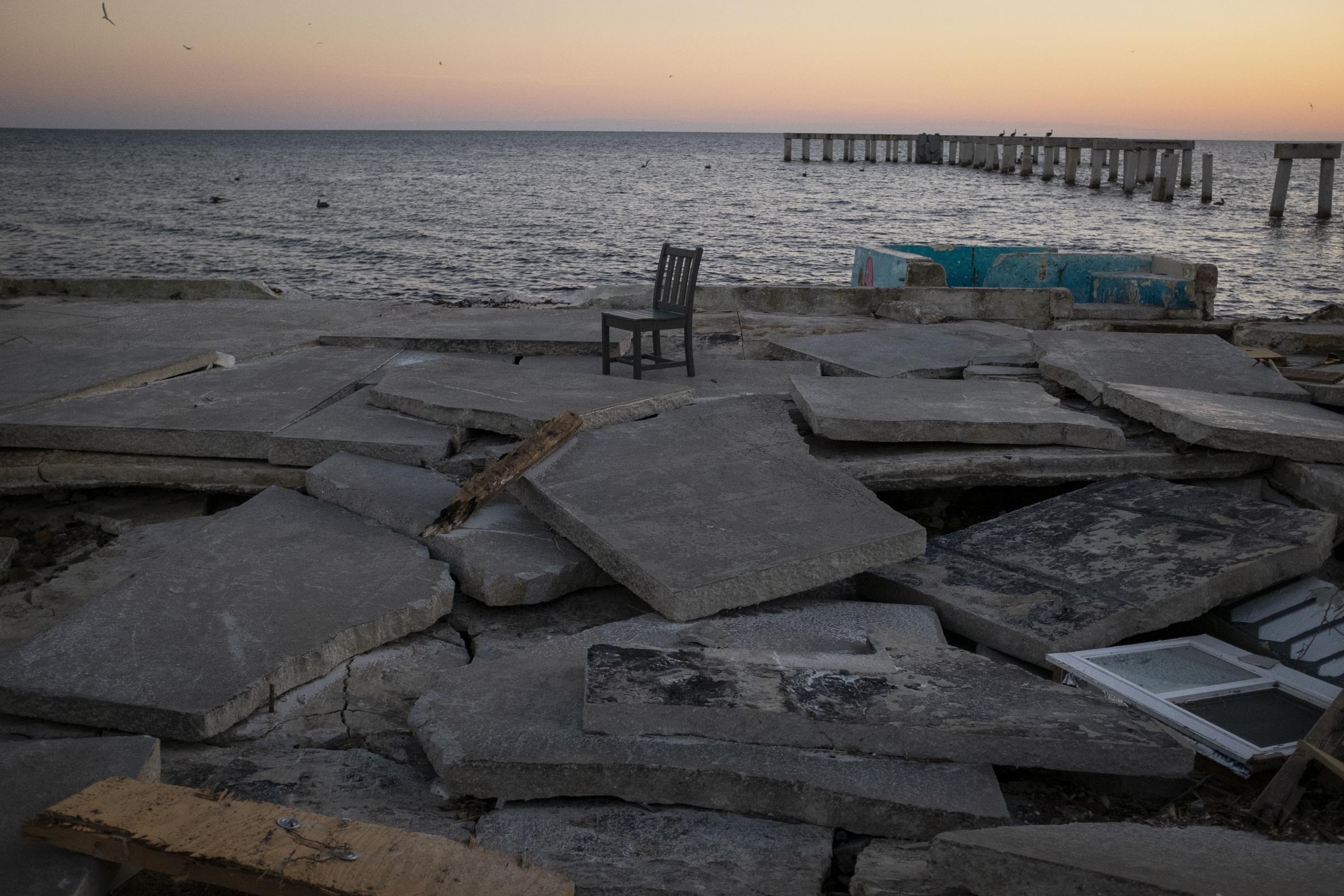 slideshow - A chair is seen at the remains of a destroyed beachfront restaurant after Hurricane Ian caused...