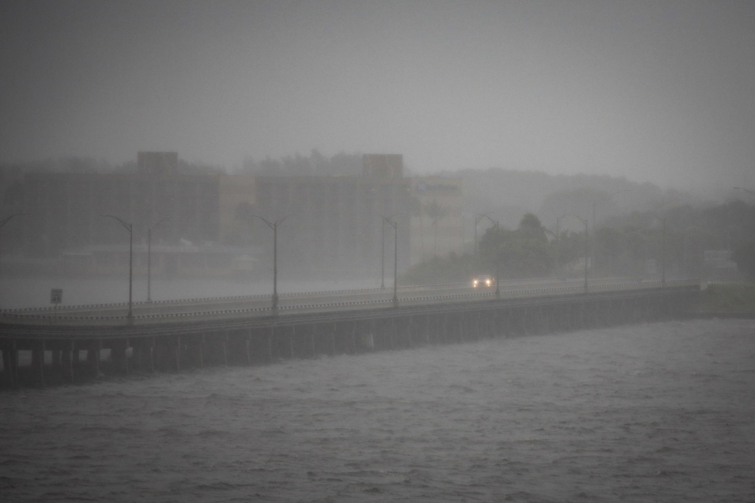 slideshow - A car is seen on Caloosahatchee Bridge ahead of Hurricane Ian, in Fort Myers, Florida, U.S....