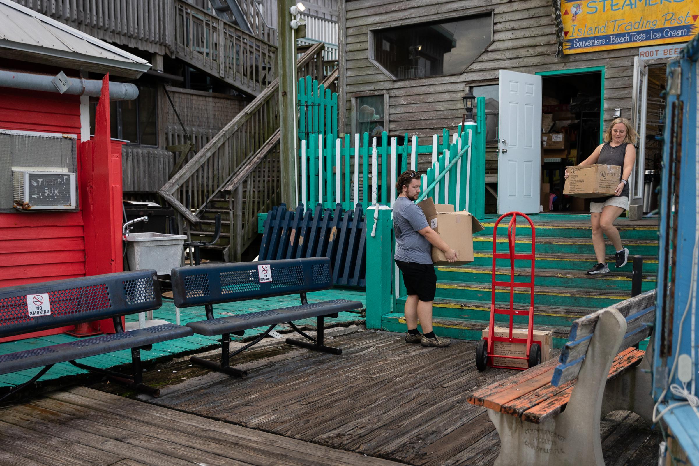 Hurricane Idalia hits Florida - People carry boxes out of a gift shop ahead of the...